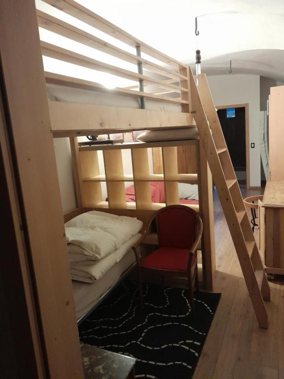 RoncegnoAl Volto的配有双层床和椅子的房间