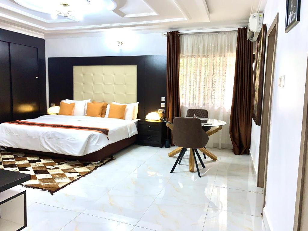 阿布贾UrbaN RootZ的一间卧室配有一张床、一张桌子和一把椅子