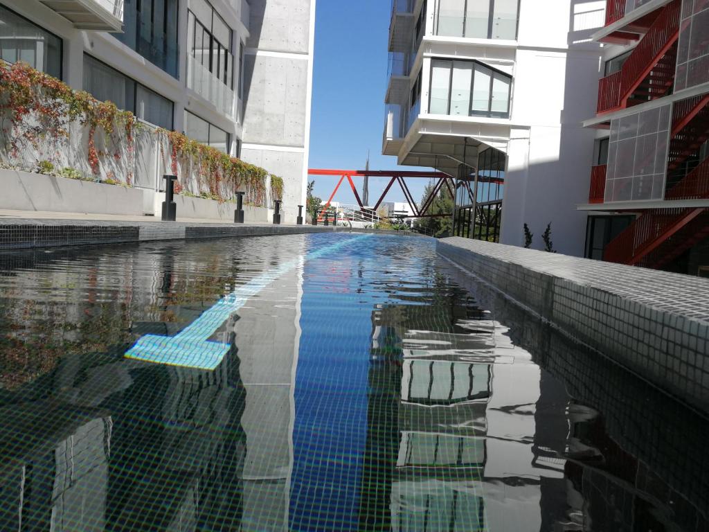危地马拉Encanto Cayala, Apartamento moderno a minutos caminando de Embajada USA y Paseo Cayala的一座建筑物中央的游泳池
