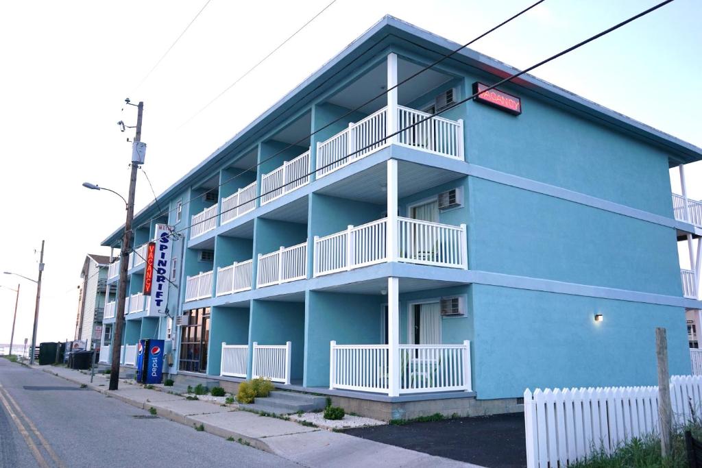 大洋城浪花汽车旅馆的蓝色的建筑,设有白色阳台,位于街道上