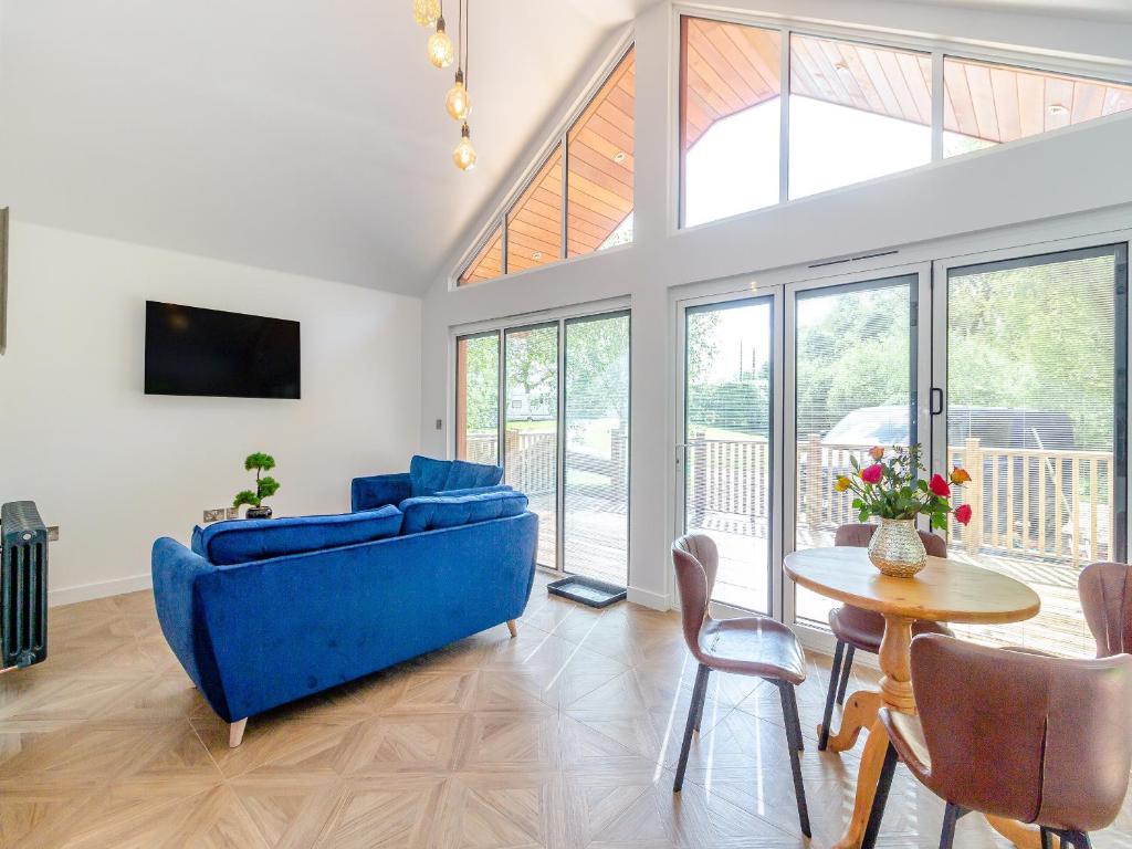 科尔福德Greenacres Cabin的客厅配有蓝色的沙发和桌子