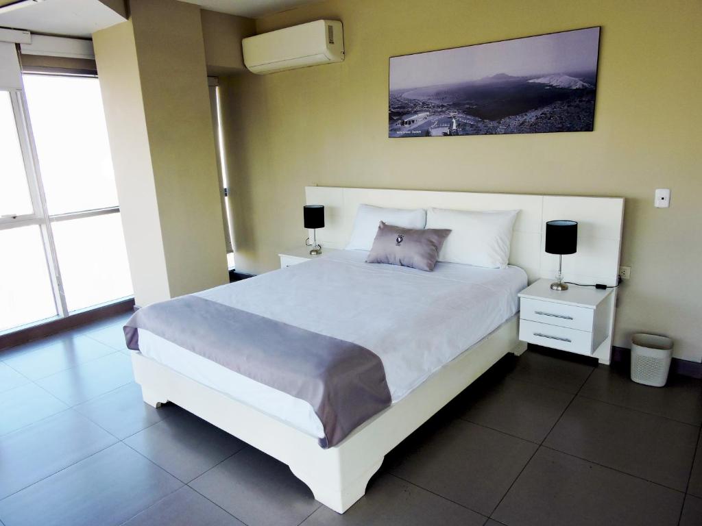 钦博特Hotel Viera Chimbote的卧室配有一张白色大床和两盏灯。
