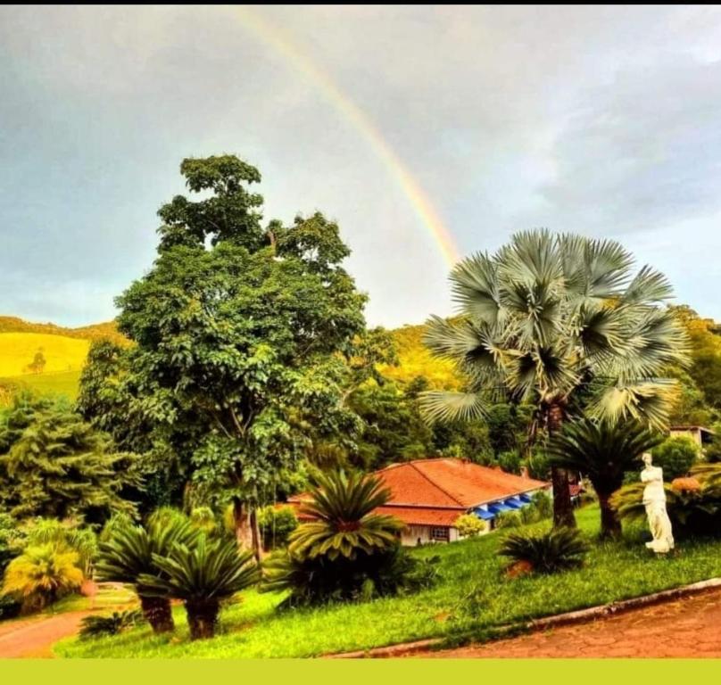 圣洛伦索Pousada NAIF的棕榈树屋上方的天空彩虹