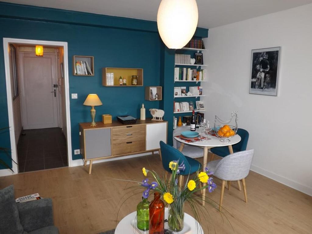 欧里亚克Appartement Aurillac, 2 pièces, 2 personnes - FR-1-742-389的客厅配有桌子和蓝色的墙壁