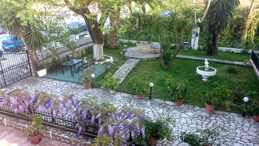 罗达Maritsas Apartments的鲜花盛开的花园和一个喷泉
