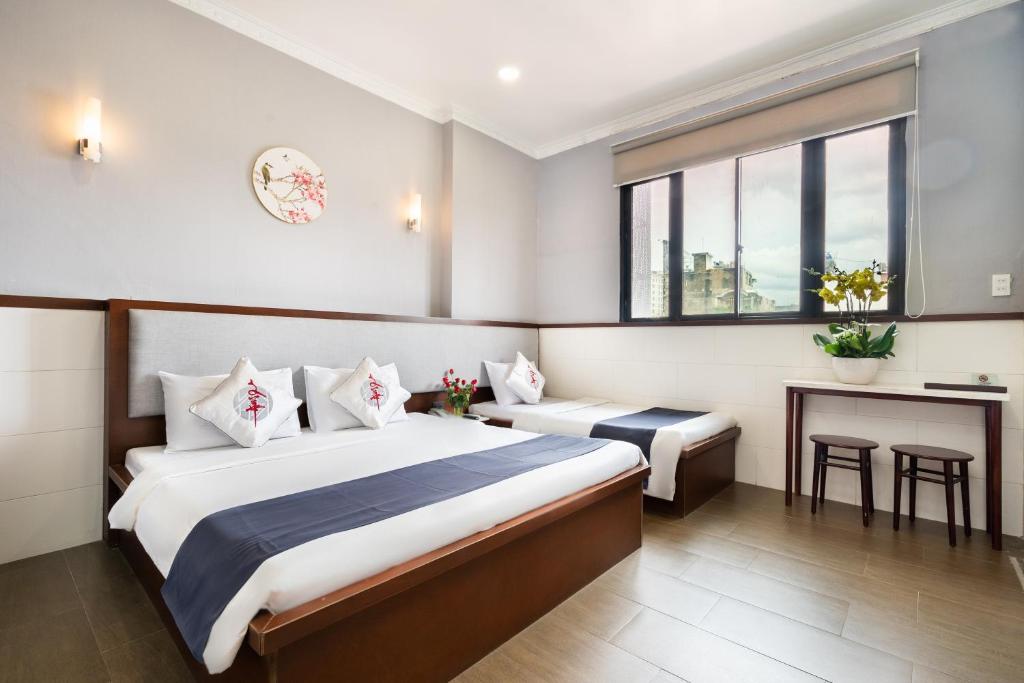 胡志明市Văn Hoa Hotel的配有一张床和一张书桌的酒店客房