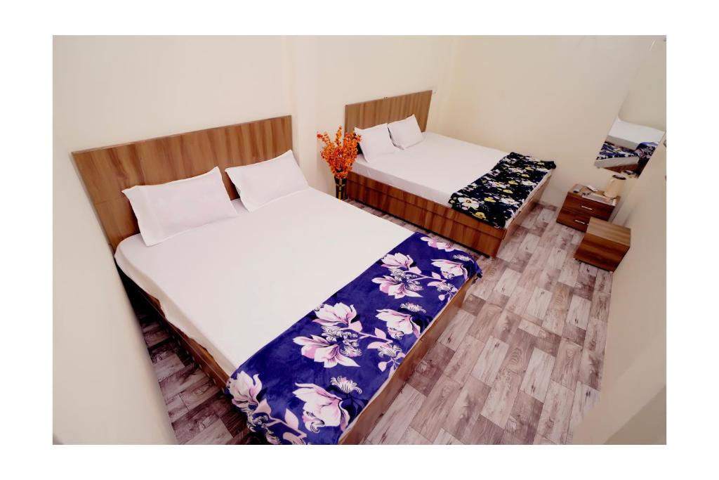 乌贾因Rajdarshan Hotel的小型客房配有两张床,