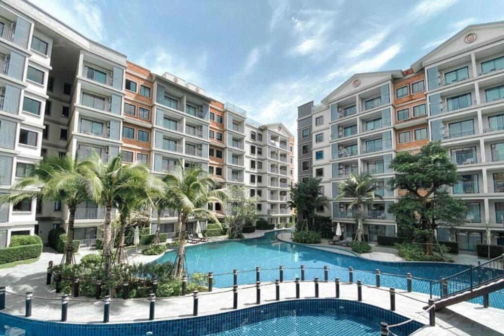 奈扬海滩2 Bedroom Apartment in Naiyang - The Title Residences, Naiyang的公寓大楼设有游泳池和棕榈树