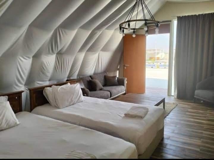 Al ḨamrānīyahDesert Breeze Farm Resort的一间卧室配有两张床和一张沙发。
