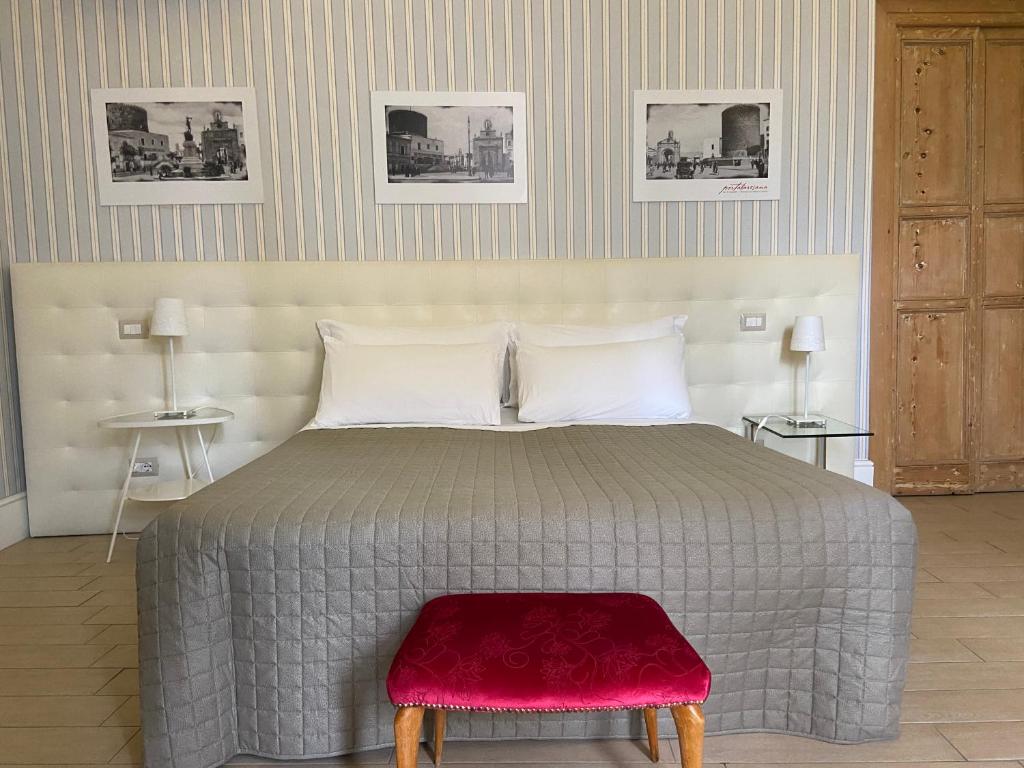 比通托B&B Porta Baresana的一间卧室配有一张大床和红色凳子