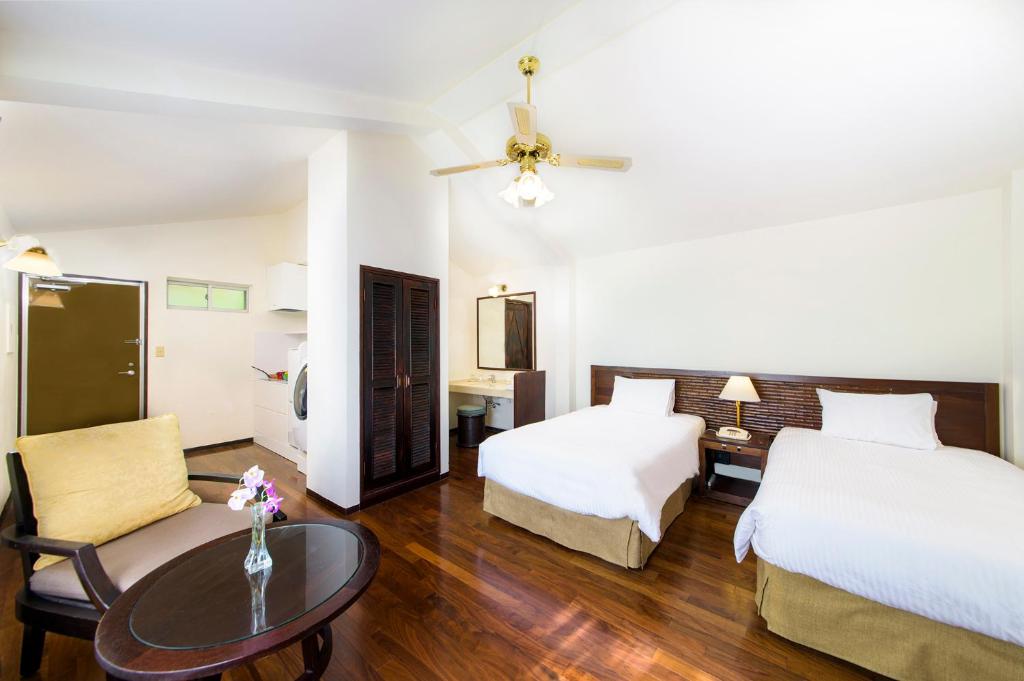 宇流麻冲绳可可花园酒店的酒店客房设有两张床和一张桌子。