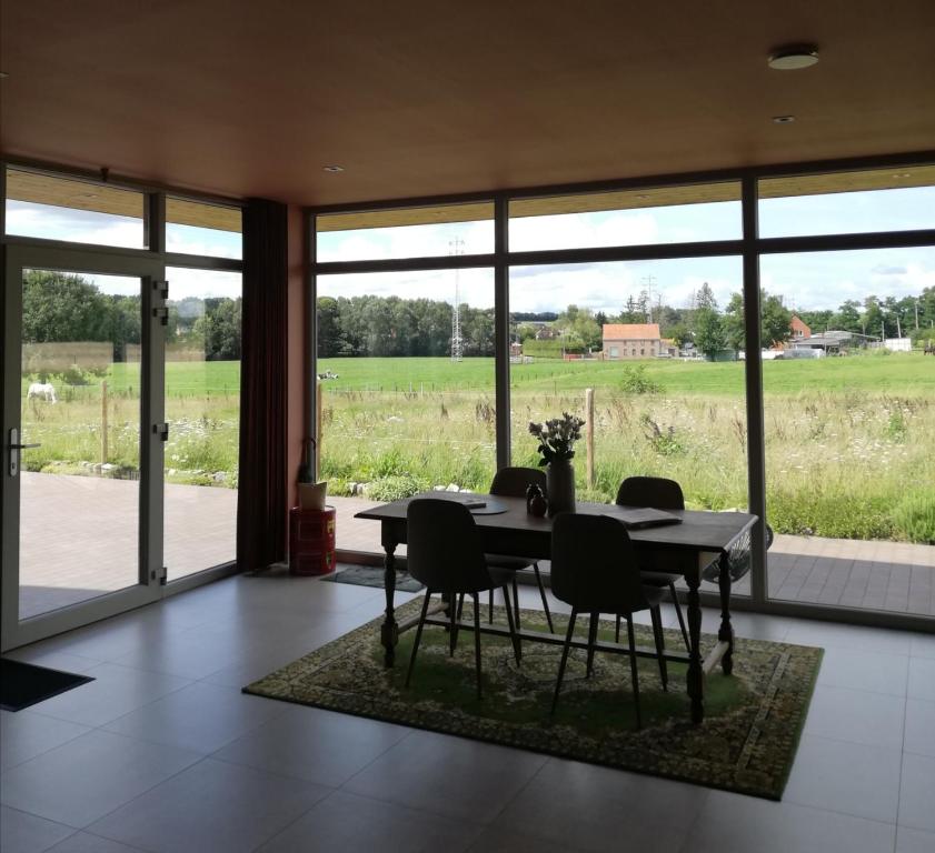 KortenakenRoos 14, sfeervol vakantieverblijf in hartje Hageland的一间配备有桌椅的用餐室,享有田野美景