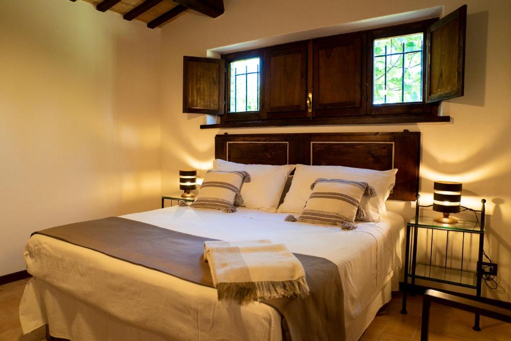 西维尔诺瓦·马尔凯La Capparuccia的卧室配有一张白色大床和两个窗户
