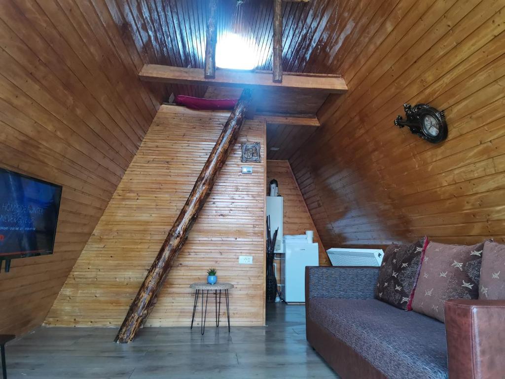阿尔杰什河畔库尔泰亚Cabana Ema的沙发间的木楼梯