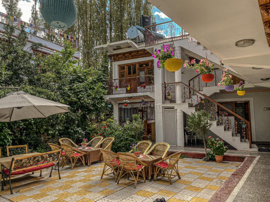 列城Hotel shaynam的庭院配有桌椅和遮阳伞。