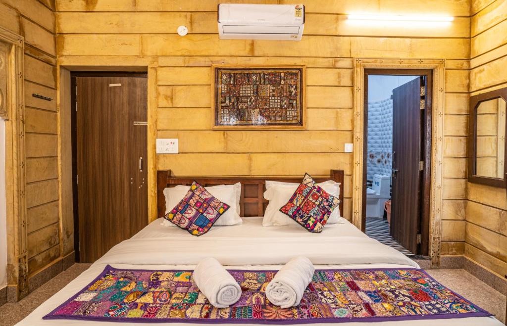 斋沙默尔Hotel Relax Inn Jaisalmer的一间卧室配有带枕头的床