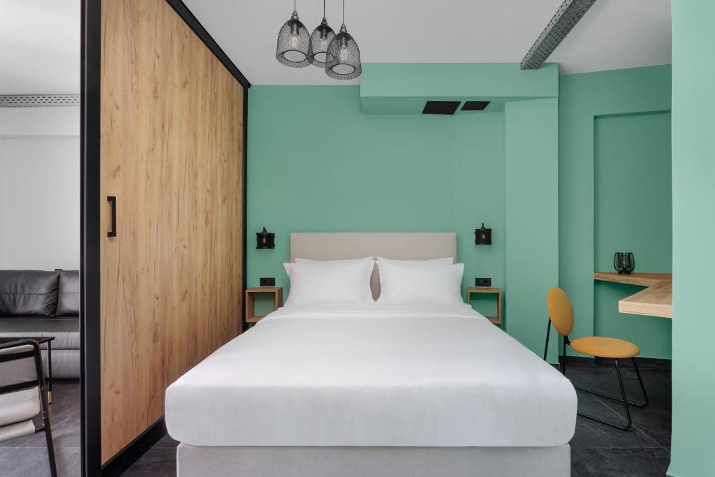 约阿尼纳THE URBANIST •inner city residences•的卧室配有白色的床和蓝色的墙壁