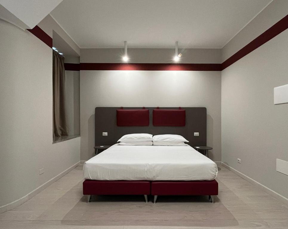 伊夫雷亚Borgo Yporegia的一间卧室配有一张大床和红色床头板