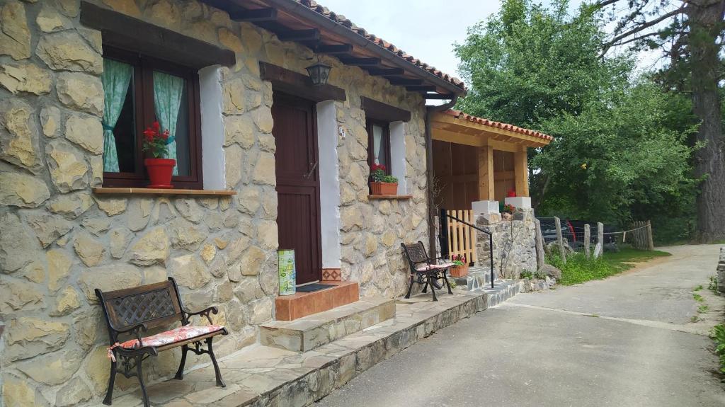 NavaLa Casa de la Vieja的前面有两长椅的石头房子