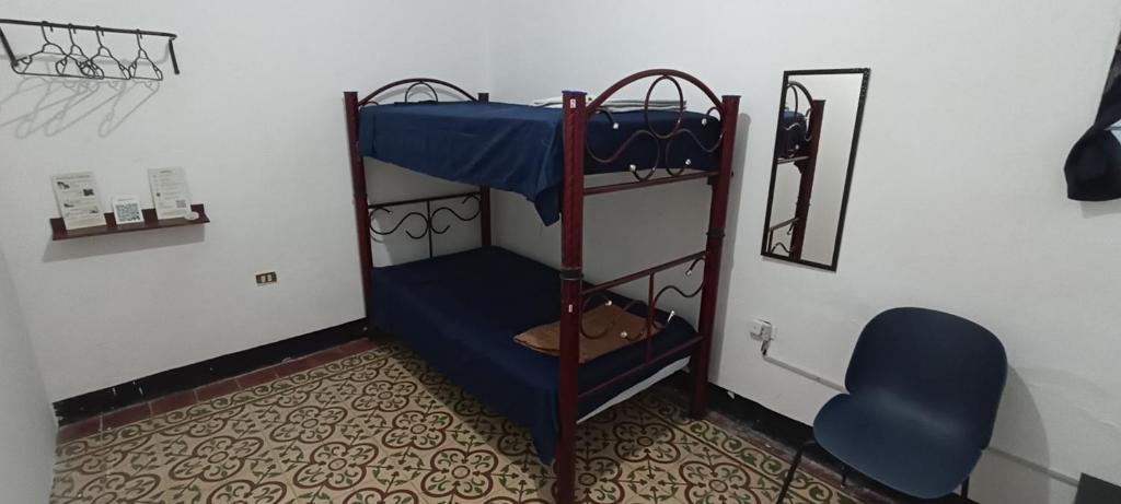 奥里萨巴Hostal Casa Azul, Chantli的带两张双层床和蓝色椅子的房间