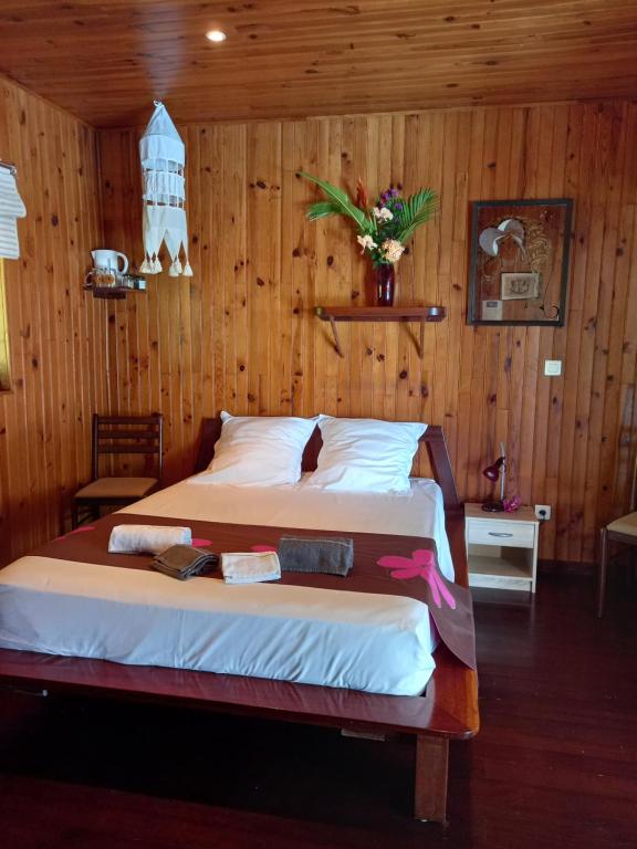 乌图罗阿Villa U'upa的卧室配有木墙内的一张床
