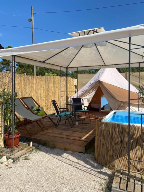 扎达尔Camping Perla的一个带桌椅和游泳池的帐篷