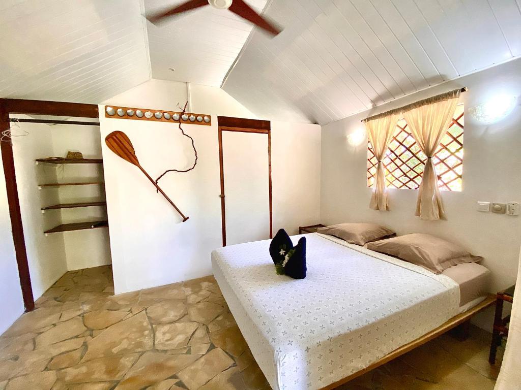 阿瓦托鲁Poe Guesthouse的一间卧室配有一张床和吊扇