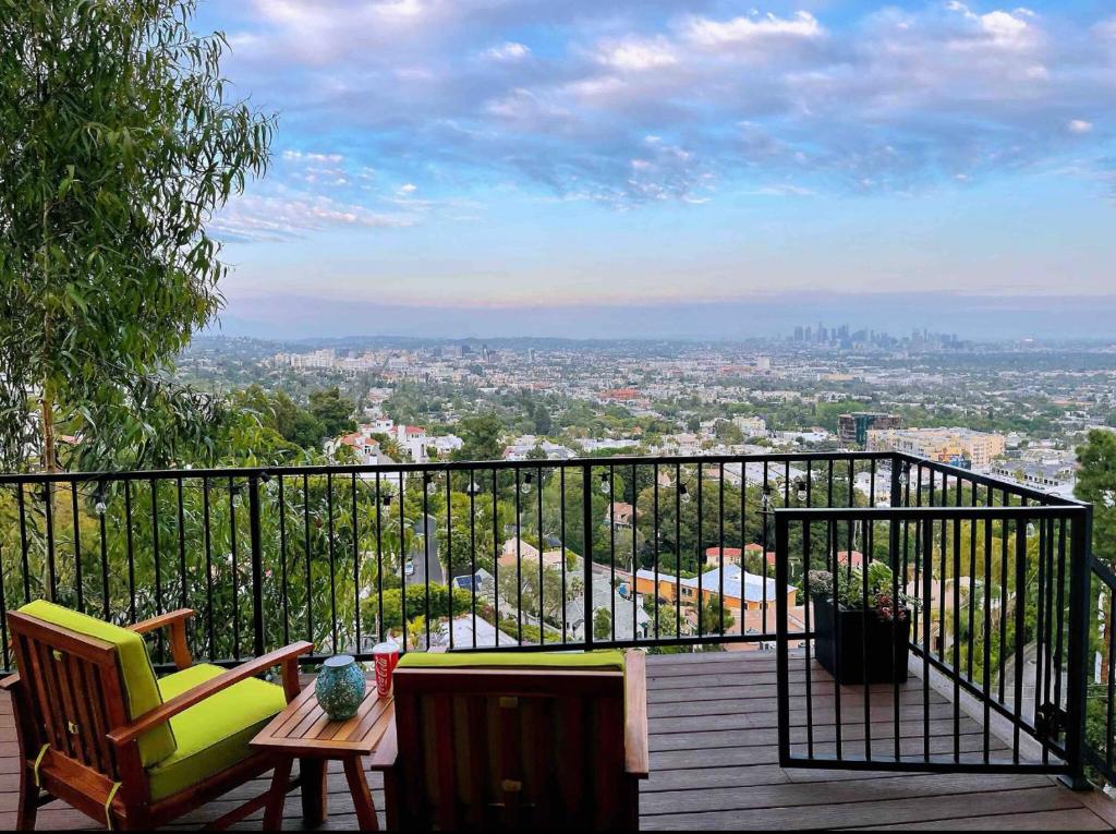 洛杉矶Stunning View Hollywood Hills Guest House的阳台配有桌椅,享有城市美景。