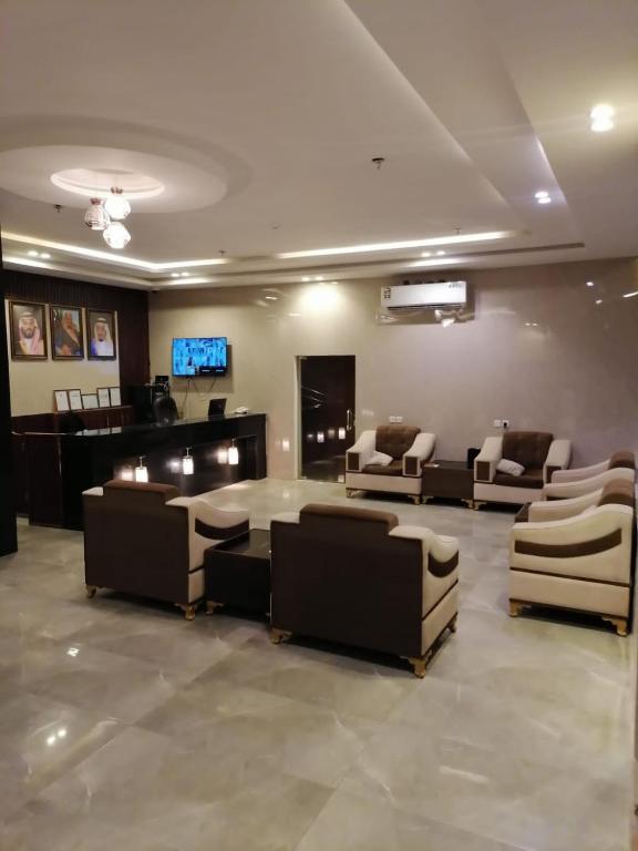Sīdī Ḩamzahفندق اضواء المدينة的带沙发、桌子和电视的等候室