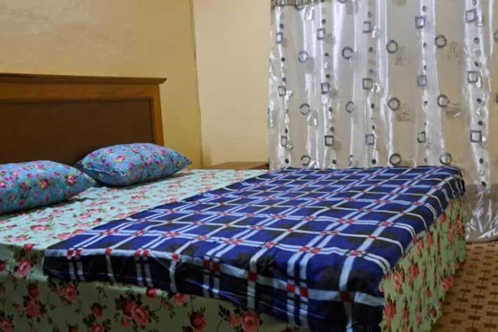 瓦加杜古Villa 2 chambres-Salon的一张带蓝色和白色棉被和枕头的床