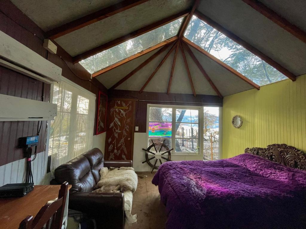 威廉斯港Refugio El Cauque的一间卧室配有紫色的床、沙发和窗户