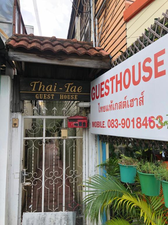 华欣ThaiTae GuestHouse HuaHin的旅馆的前门有标志