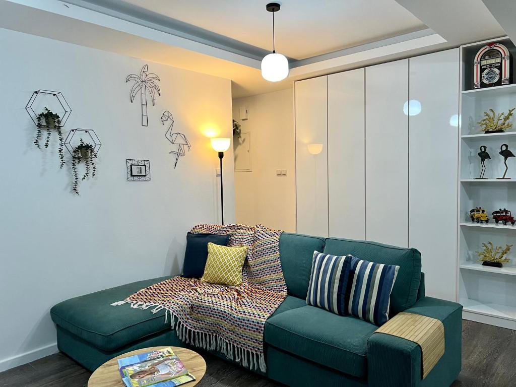 拉纳卡Fat Cow Apartment 01的客厅配有绿色沙发和桌子