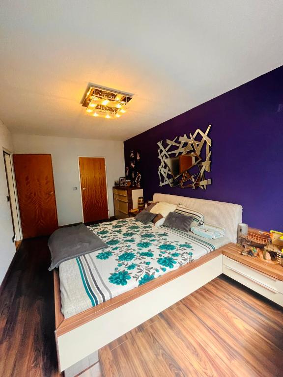 维也纳10 min from U1 - Private room in shared apartment的一间卧室配有一张大床和紫色墙壁