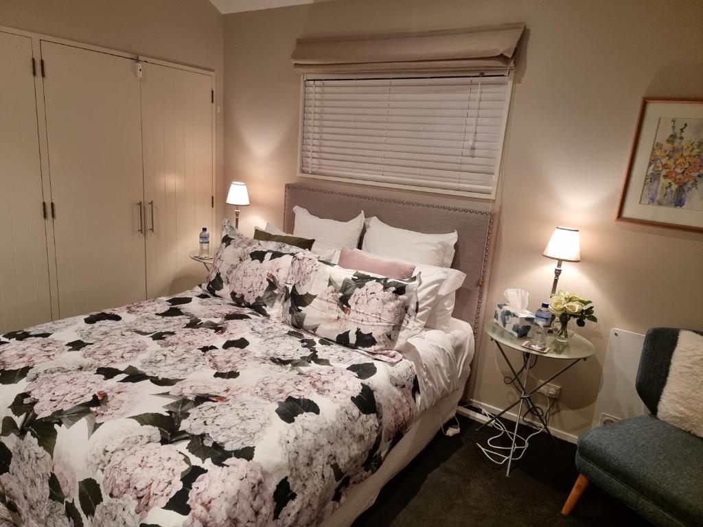 皇后镇Haven Sanctuary Suite with Private Entrance的卧室配有带鲜花的黑色和白色床。