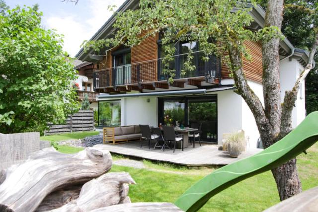 奥博奥多夫Ferienhaus Freiheit - Modernes Haus in alpenländischem Stil für Urlaub und Workation in bester Lage am Fuß der Alpen的房屋前有雕像的房子