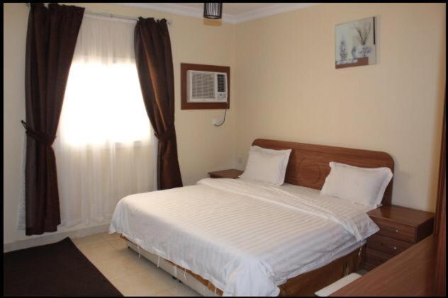 麦地那Zahret Al Madinah的一间卧室设有一张大床和一个窗户。