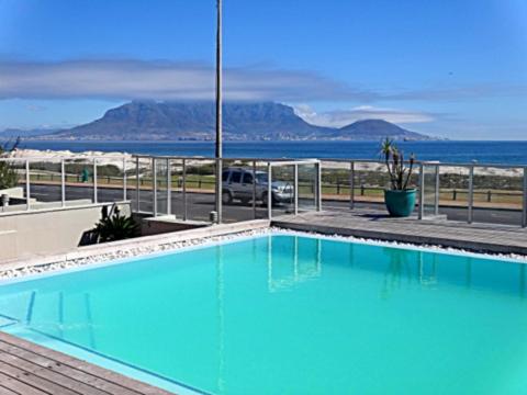 布鲁堡史特兰Cape Town Beachfront Accommodation in Blouberg的蓝色的海景游泳池