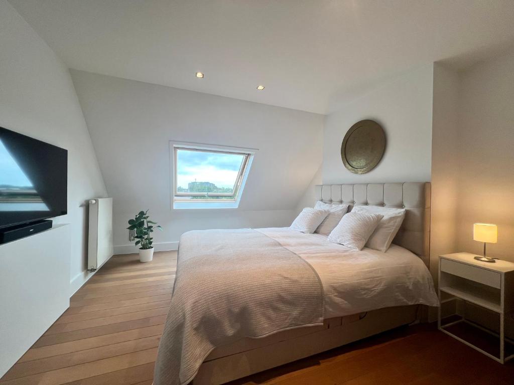 赫尔Luxury Business Accommodation Geel的一间白色卧室,配有床和电视