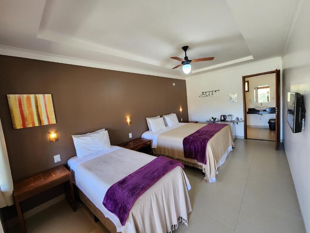 戈亚斯州上帕莱索Pousada Camarás的酒店客房配有两张床和吊扇。