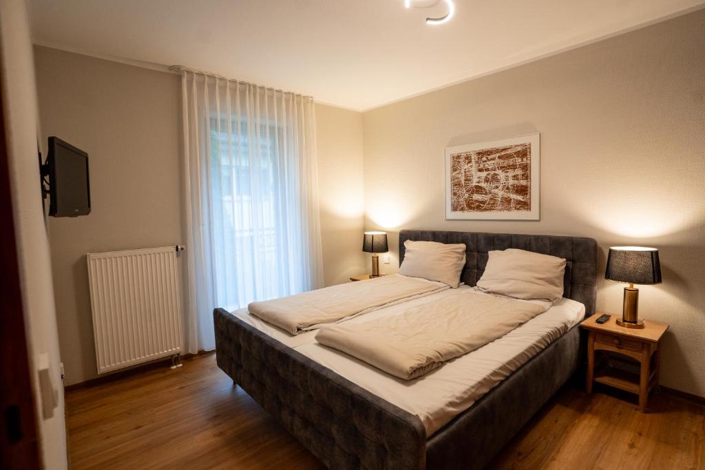 巴特萨尔茨乌夫伦Boardinghouse CityHome am Kurpark的一间卧室设有一张大床和一个窗户。