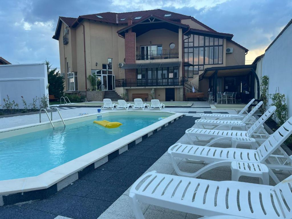 百乐费利克斯Thermal Family Resort的一个带躺椅的游泳池以及一间房屋