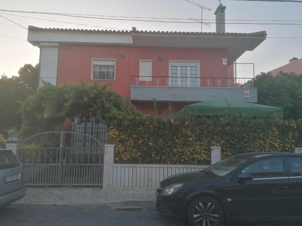 River City House的一座粉红色的房子,前面有一辆汽车
