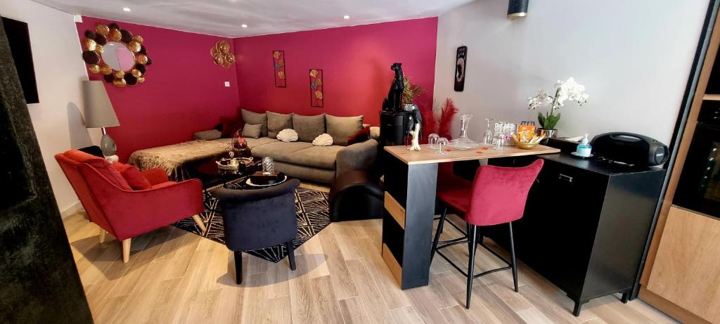 Feigèresappartement cosy的客厅配有沙发和带红色椅子的桌子