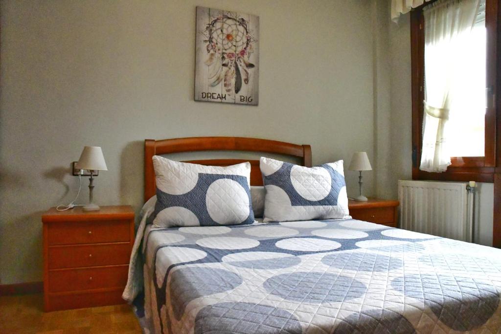 阿维莱斯Puerta la Villa的一间卧室配有一张带蓝色和白色棉被的床