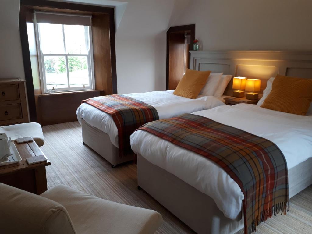 斯特兰拉尔Corsewall Arms Guest House的酒店客房设有两张床和窗户。
