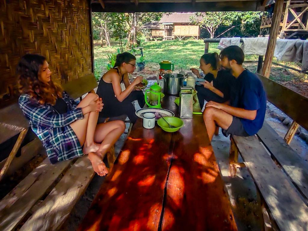TimbanglawangWild Camp的一群人坐在木桌旁