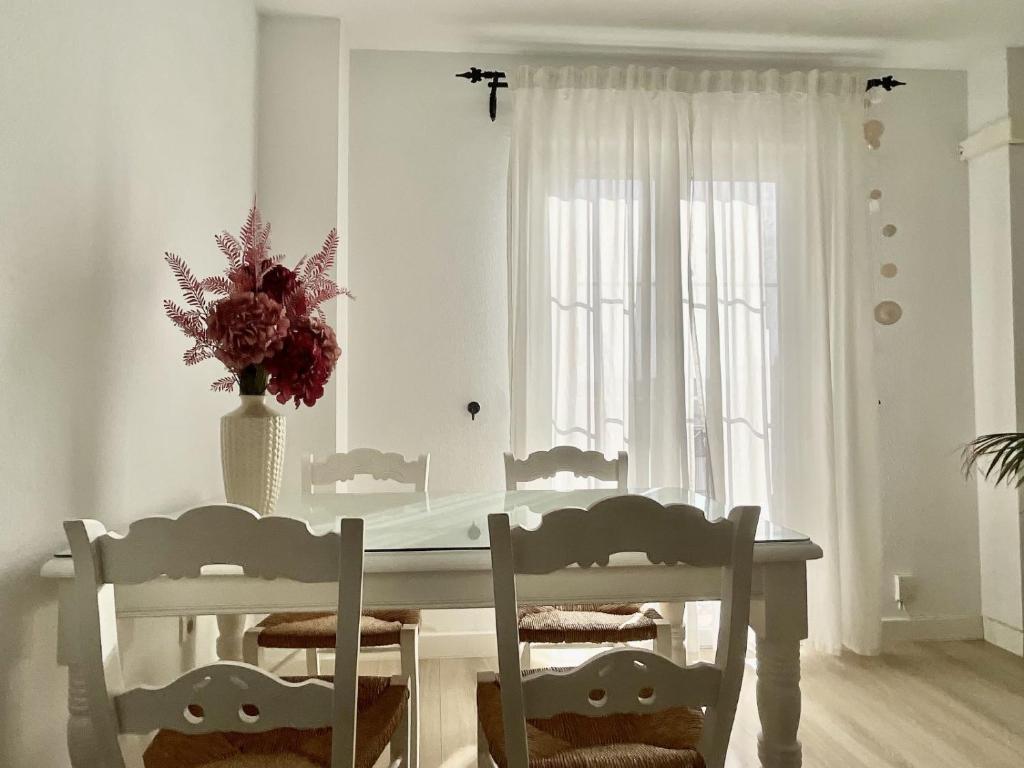 隆达Apartamento Ronda Centro的白色的用餐室配有白色的桌椅