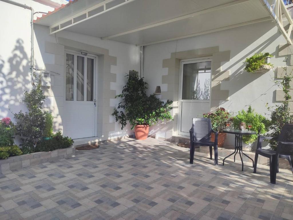 耶奥伊乌波利斯Yannis apartments的一个带植物和桌椅的庭院
