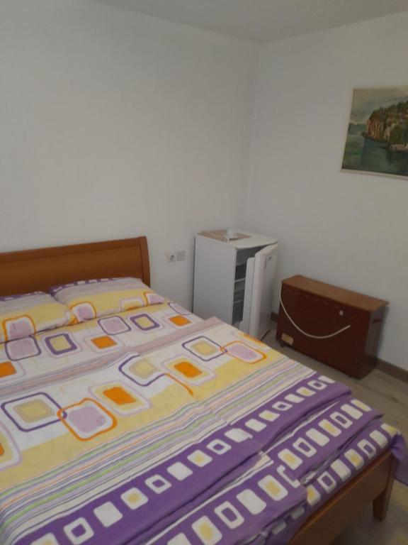 奥赫里德Vila Veronika ul Dame Gruev 207 Ohrid的一张床上有五颜六色的毯子,放在房间里